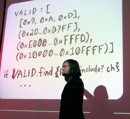 why-the-lucky-stiff in front of a projection screen of a whiteboard of his code.
